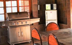 uma cozinha com uma mesa, um fogão e um frigorífico em Hoopstad Guesthouse em Hoopstad