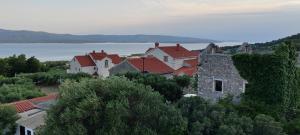 a group of houses on a hill next to the water at Apartman Bernardica in Bol