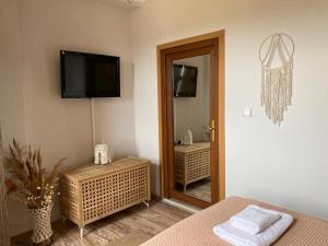 1 dormitorio con espejo y TV en la pared en Vayu Hotel&Tiny Houses, en Canakkale