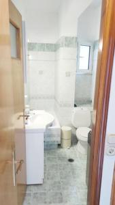 Kóronos的住宿－Serenity apartment，白色的浴室设有水槽和卫生间。