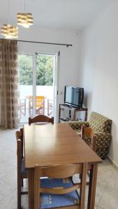 einen Holztisch und Stühle im Wohnzimmer in der Unterkunft Serenity apartment in Kóronos