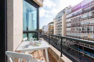 una mesa blanca y sillas en un balcón con vistas en Apartamento Marques de Salamanca, en Marbella