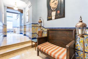ławka w korytarzu z obrazem na ścianie w obiekcie Casa de Alma w Maladze