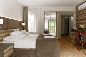 a hotel room with a large bed and a kitchen at Hotel Villa Eva in Gdańsk