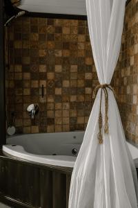 a bath tub with a curtain in a bathroom at Live in the woods in Mikhmannim