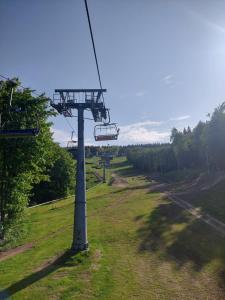 eine Gondelbahn auf einem Feld mit einem Grasfeld in der Unterkunft Ubytování U Janičky in Klíny