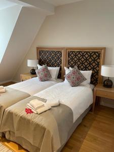 a bedroom with a large bed with two towels on it at Hotel Himmel und Havel in Berlin