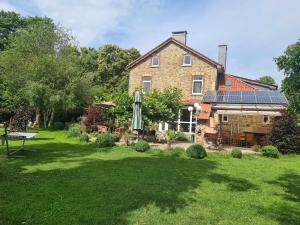 a large brick house with an open yard at La Maison des Roses in Francorchamps