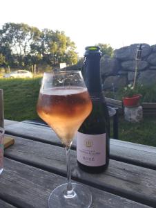 un bicchiere di vino e una bottiglia sul tavolo di La Roulotte romantique du P'tit Buron a Saint-Saturnin