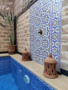 a bathroom with a blue tub with a tiled wall at Villa Dar Bella in Aït Ali