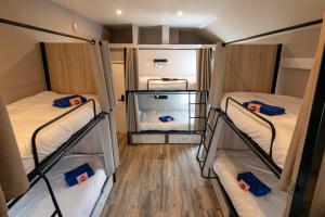 three bunk beds in a room with wooden floors at Peggy Moores in Drogheda