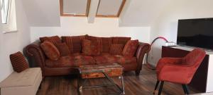 sala de estar con sofá marrón y TV en Hideaway en Zell am Moos