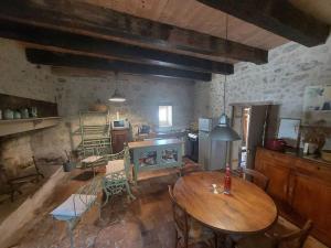 sala de estar con mesa de madera y cocina en Maison en pierre à Laroque-Timbaut - Clévacances 3 clés, en Laroque-Timbaut