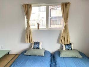 Duas camas num quarto com uma janela em Arts Candy Sapporo-Villa Nakajima em Sapporo