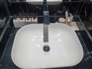 La salle de bains est pourvue d'un lavabo blanc et d'un robinet. dans l'établissement 4 Br Villa with cinema luxury, à Hanoï