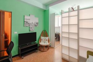 een woonkamer met een tv en een groene muur bij House of colours in Marconi, Roma in Rome