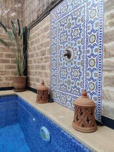 a bathroom with a blue tub with a tile wall at Villa Dar Bella in Aït Ali