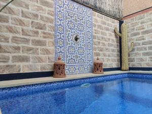 a swimming pool with a tile wall next to a swimming pool at Villa Dar Bella in Aït Ali