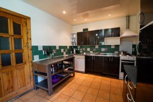 a kitchen with green and white tiled walls at Alaušo Salos - Malinauskų kaimo turizmo sodyba in Sudeikiai +19 photos