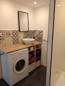 a bathroom with a washing machine and a sink at La Lavandière in Puimoisson