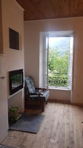 a living room with a chair and a window at Gite de l'école 