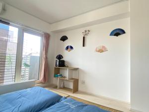 a bedroom with a blue bed and a window at Arts Candy Sapporo-Villa Nakajima in Sapporo
