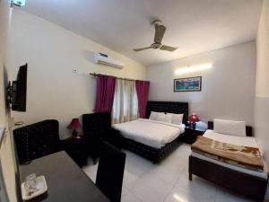 a hotel room with a bed and a couch and a room at Travel Inn islamabad in Islamabad