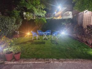 a garden at night with two chairs and lights at Travel Inn islamabad in Islamabad