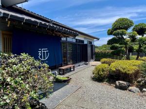 una casa azul con un banco delante en 島の宿 近 別邸〜縁〜 en Oshima