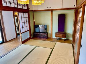 a living room with a tv and a table at 島の宿 近 別邸〜縁〜 in Oshima