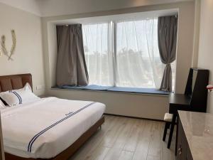 a bedroom with a bed and a large window at Claire Aparthotel in Kigali