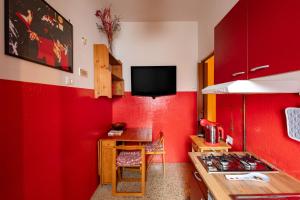 een keuken met rode muren, een tafel en een fornuis bij House of colours in Marconi, Roma in Rome