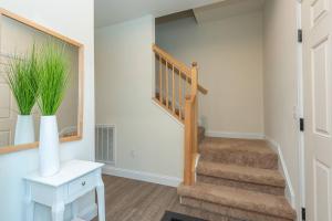 a hallway with a staircase with a vase of grass at Panorama Place! Comfy Asheville Retreat Sleeps 10! in Asheville