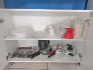 a white shelf with dishes and other kitchen items at Meu Oca in Boa Vista