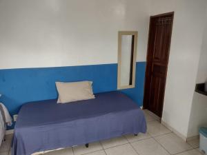 um quarto azul e branco com uma cama com uma almofada em Meu Oca em Boa Vista