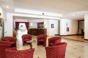 a waiting room with red chairs and a table at Etoile in Mar del Plata +8 photos