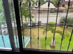 a view from a window of a yard with a palm tree at Cheerful studio apartment in Dar es Salaam