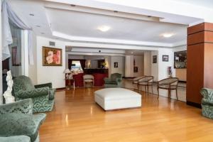 a large living room with chairs and a white ottoman at Etoile in Mar del Plata