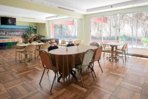 a dining room with tables and chairs and windows at Etoile in Mar del Plata