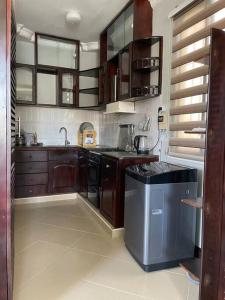 a kitchen with wooden cabinets and a dishwasher at Cheerful studio apartment in Dar es Salaam