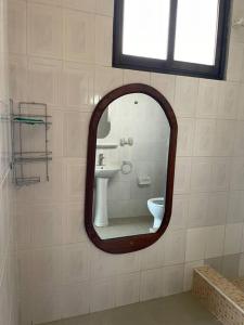 a mirror in a bathroom with a sink and a toilet at Cheerful studio apartment in Dar es Salaam