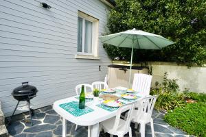 einen Tisch und Stühle mit Sonnenschirm auf einer Terrasse in der Unterkunft Le Clos de l'Anse *front de mer* in Ploemeur