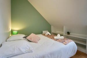 Schlafzimmer mit einem Bett mit weißer Bettwäsche und Kissen in der Unterkunft Le Clos de l'Anse *front de mer* in Ploemeur