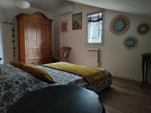 a bedroom with two beds and a cabinet and a window at Dolce Vita en Provence in Châteaurenard