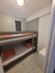 two bunk beds in a room with a mirror at COLLIOURE tres bel appart a 150 metres des plages avec jardin prive et parking dans residence securisee in Collioure