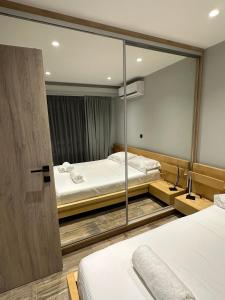 a hotel room with two beds and a mirror at Magic View 4U in Kineta