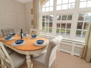 a dining room with a wooden table and chairs at Dovecote Cottage in Newcastle upon Tyne