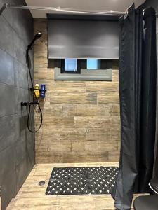 a bathroom with a shower with a black shower curtain at Magic View 4U in Kineta