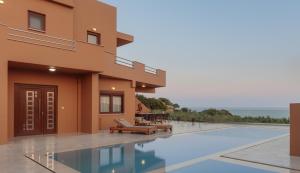 a villa with a swimming pool and the ocean at Aerope SeaView Villa, a Family Retreat, By ThinkVilla in Koutsounari