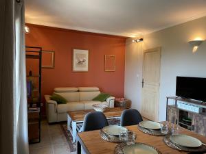 una sala de estar con un sofá, una mesa y sillas en Les jardins de la Capelière, en Méounes-lès-Montrieux